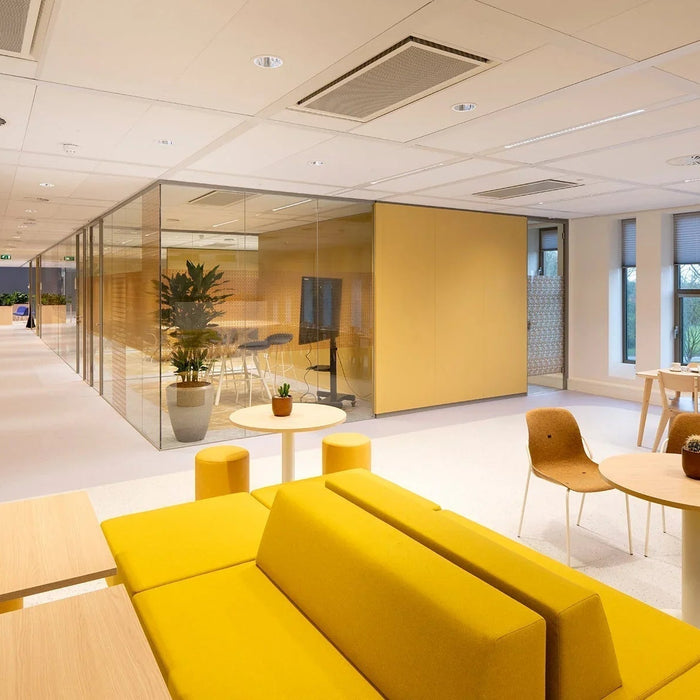 Modern kantoorinterieur met gele banken, glazen vergaderruimte en design kantoormeubilair.