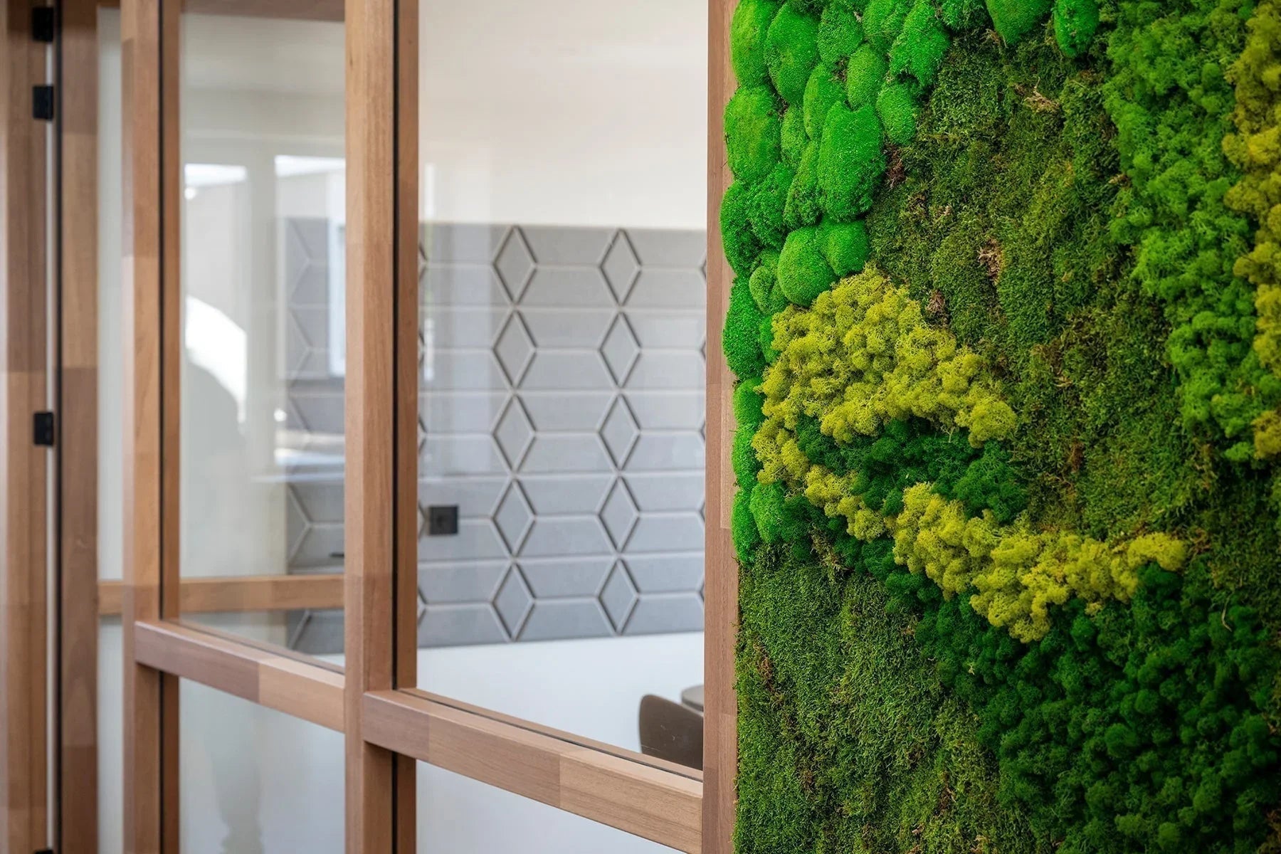 Moderne kantoorruimte met glazen wanden en groene moswand, design kantoormeubilair