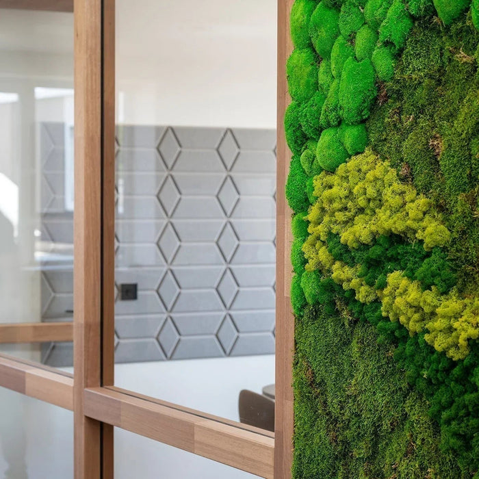 Moderne kantoorruimte met glazen wanden en groene moswand, design kantoormeubilair