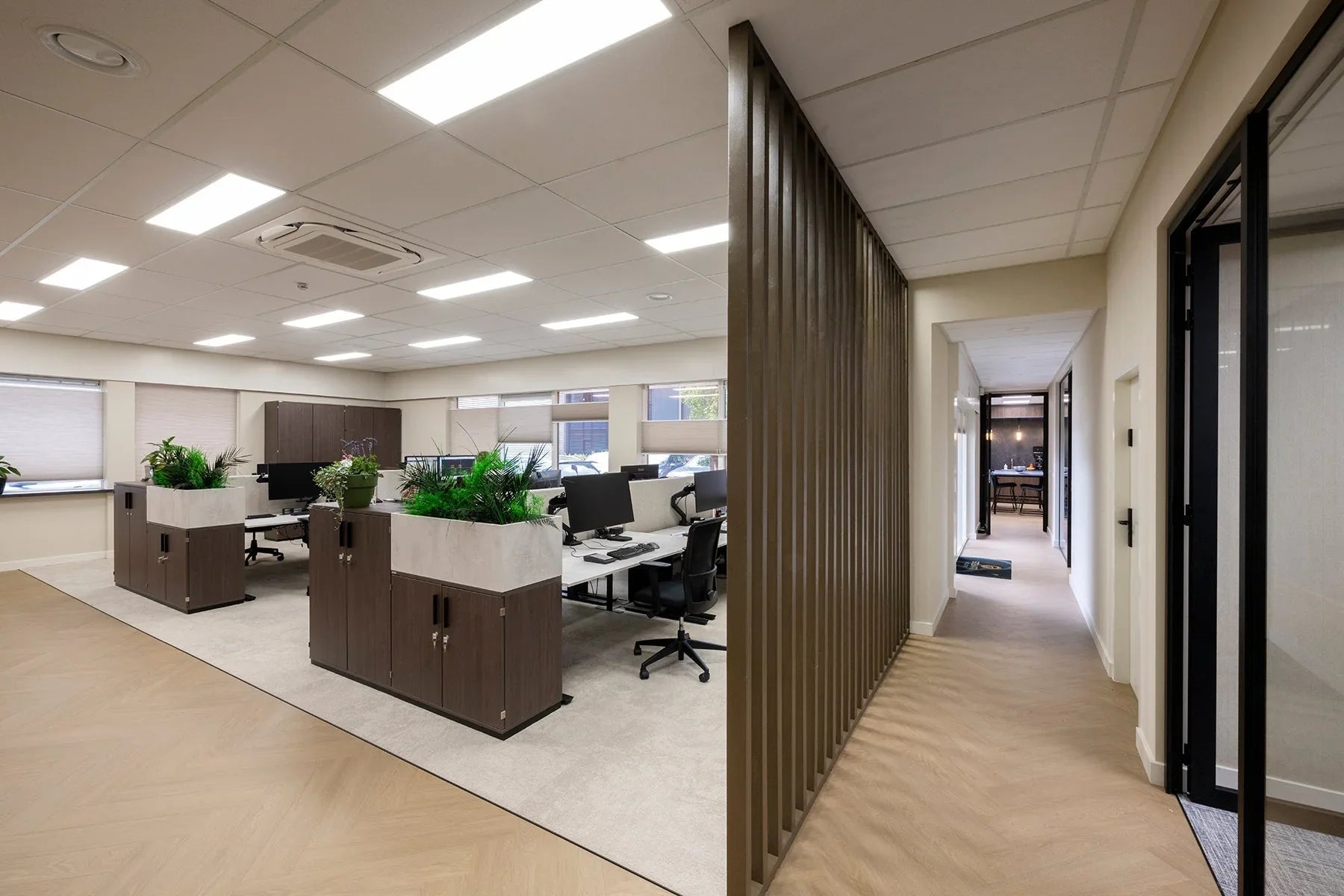 Modern kantoorinterieur met bureaustoelen, werkplekken, kasten en groene planten