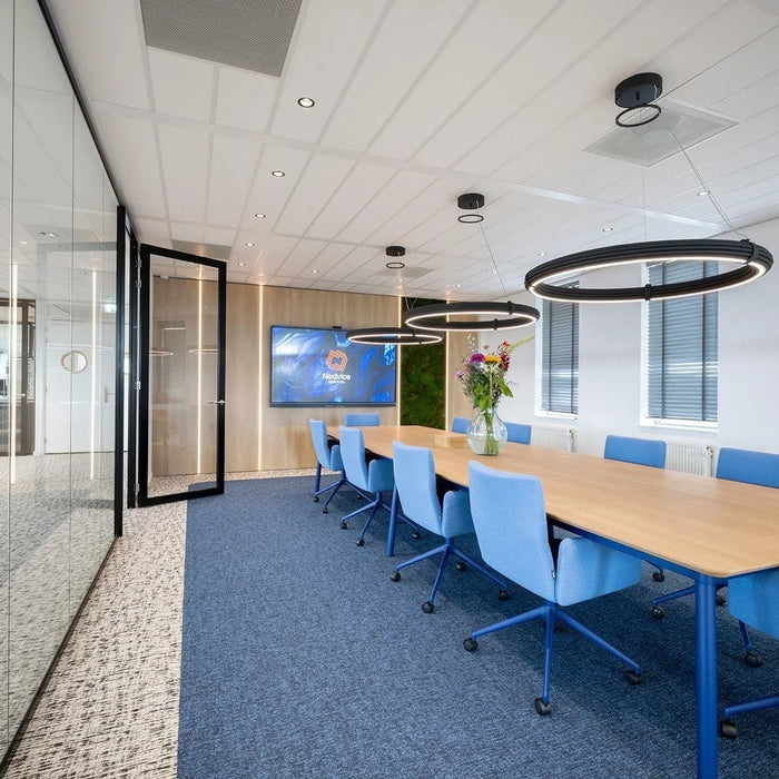 Moderne vergaderruimte met design kantoormeubilair, blauwe bureaustoelen en houten tafel.