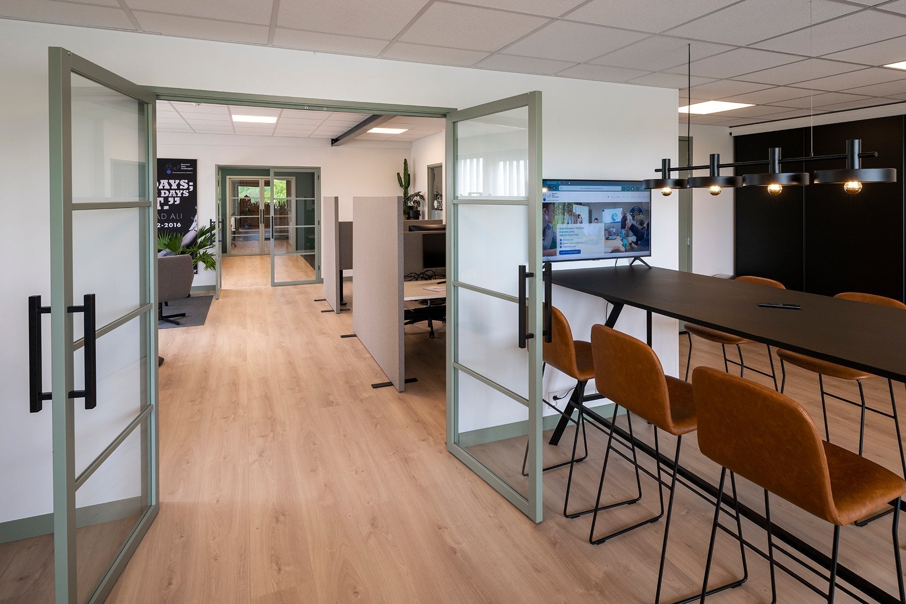 Modern kantoorruimte met vergadertafel, design stoelen en glazen deuren, kantoormeubilair online