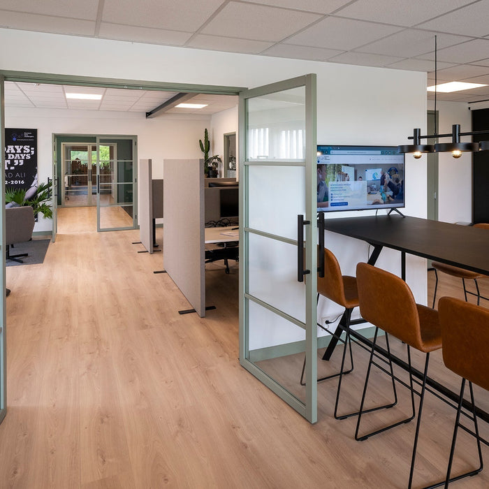 Modern kantoorruimte met vergadertafel, design stoelen en glazen deuren, kantoormeubilair online