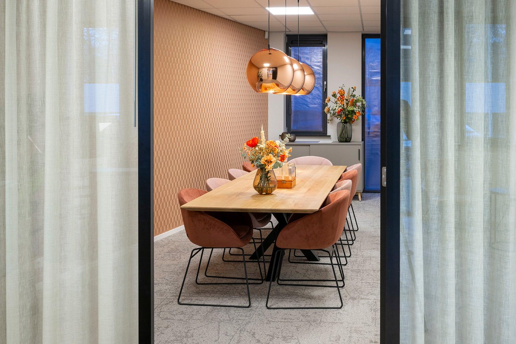 Moderne vergaderruimte met design vergadertafel, comfortabele stoelen en koperen lampen