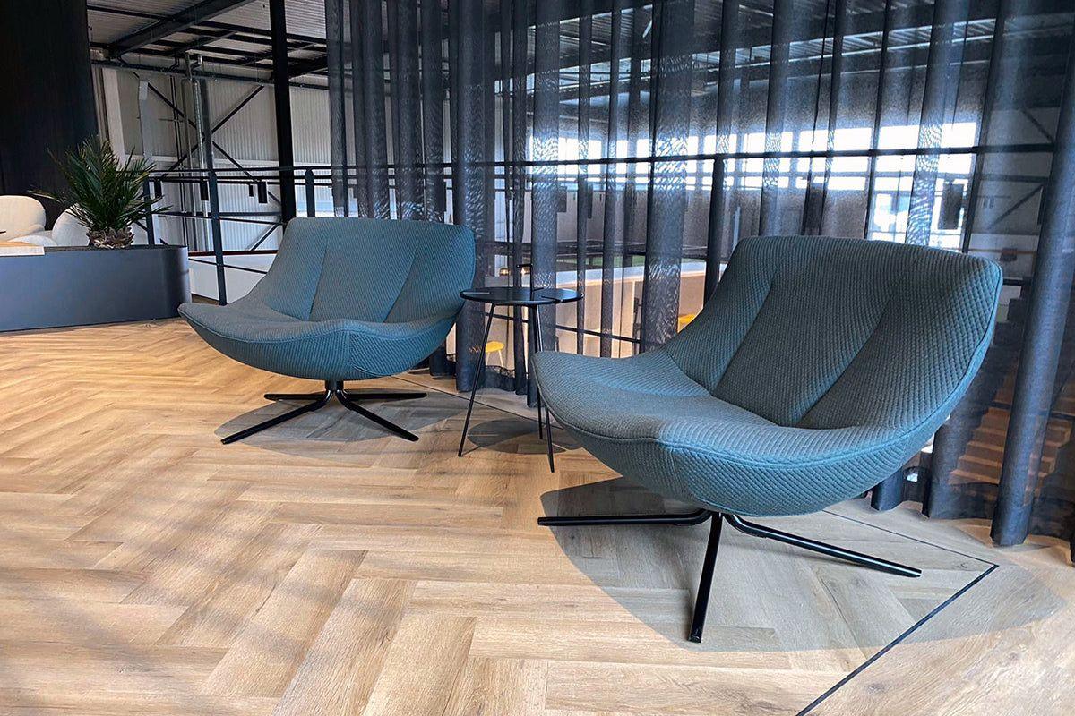 Moderne design fauteuils en bijzettafel in stijlvolle kantoorruimte met houten vloer