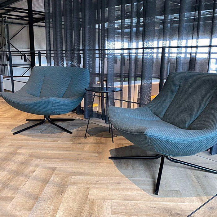 Moderne design fauteuils en bijzettafel in stijlvolle kantoorruimte met houten vloer