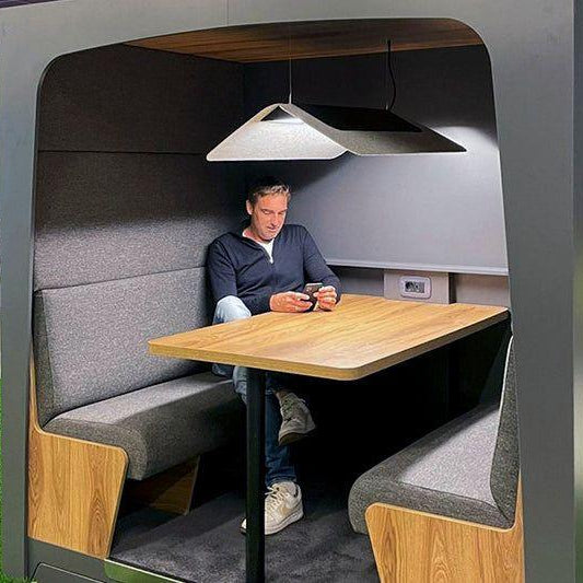 Stijlvol design kantoormeubilair met akoestische werkplek, man zittend aan houten tafel