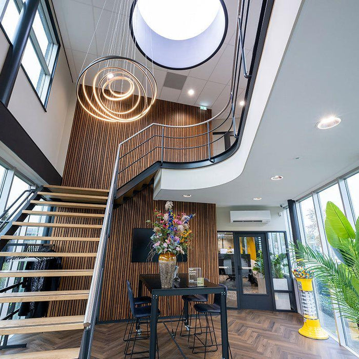 Modern kantoorinterieur met design kantoormeubels, houten trap en grote ramen.