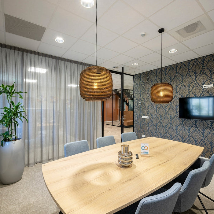 Moderne vergaderruimte met design tafel, blauwe stoelen, planten en akoestische kantooroplossingen