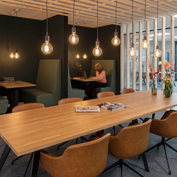 Moderne kantoorruimte met design kantoormeubels, vergadertafel, leren stoelen en sfeerverlichting