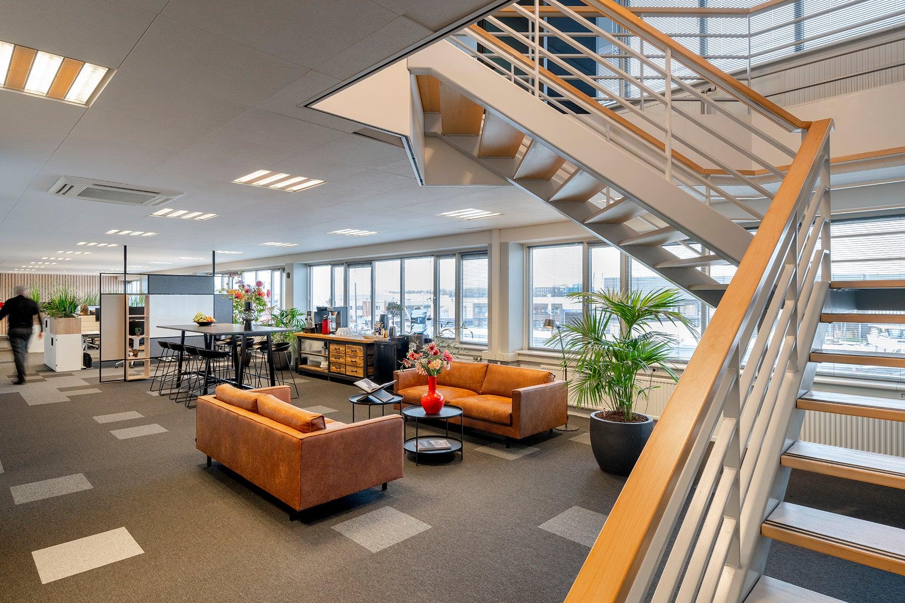 Modern kantoorinterieur met design kantoormeubels, zithoek en grote ramen, KANTOORMEUBELS.ONLINE