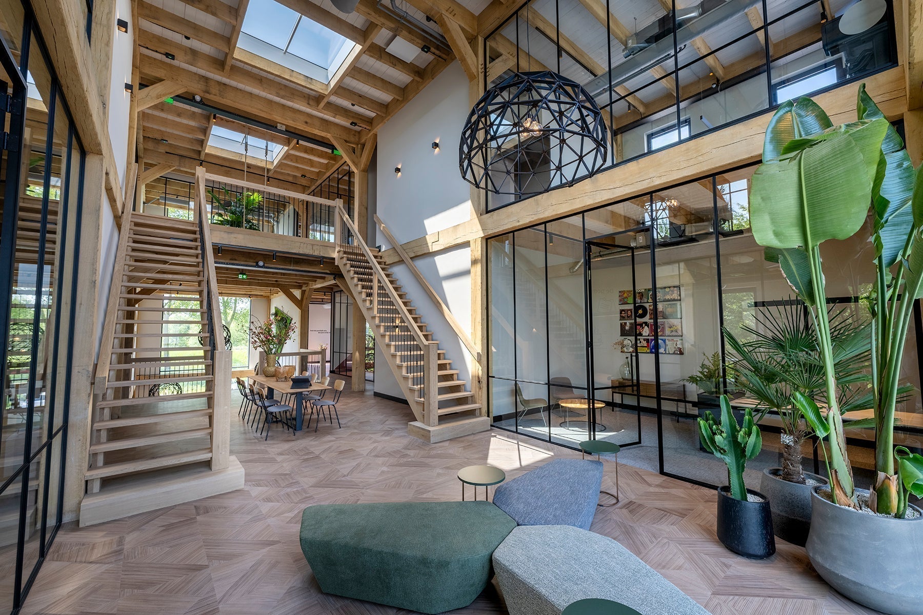 Modern kantoorinterieur met design kantoormeubilair, houten trap en veel planten