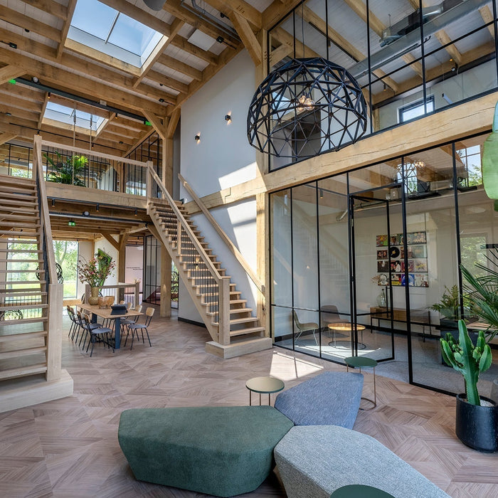 Modern kantoorinterieur met design kantoormeubilair, houten trap en veel planten