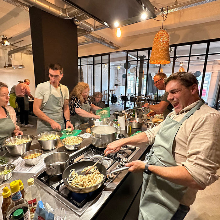 Teamuitje koken in moderne keuken, groep collega's bereidt samen eten, gezellige sfeer