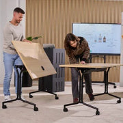 Twee mensen zetten klaptafels op kantoor 