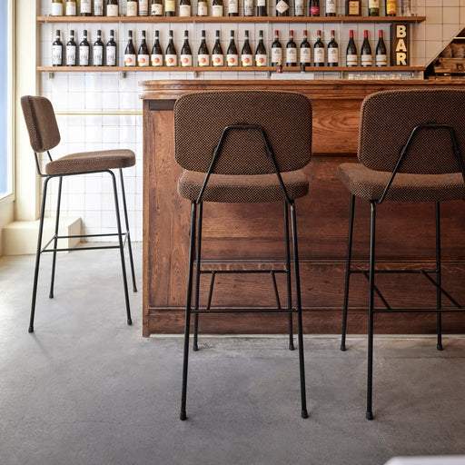 Artifort Moulin barkrukken aan houten bar met wijnflessen in wandrek