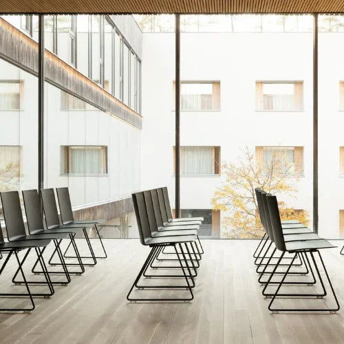 BATCH zaalstoelen in design kantoorruimte met grote ramen en houten vloer