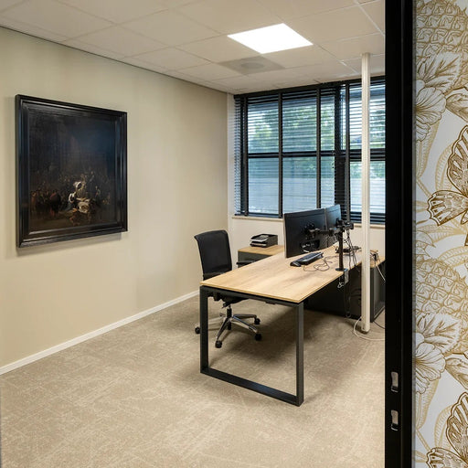 Modern directiebureau met houten blad, zwarte poot, bureaustoel en dubbele monitor in kantoorruimte.