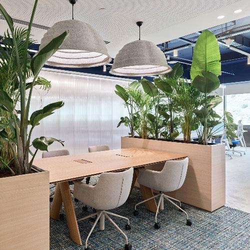 Moderne kantoorruimte met design vergadertafel, bureaustoelen en veel groene planten