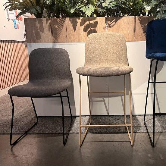 Twee moderne design barkrukken met stoffen zitting in kantoorruimte, kantoormeubilair