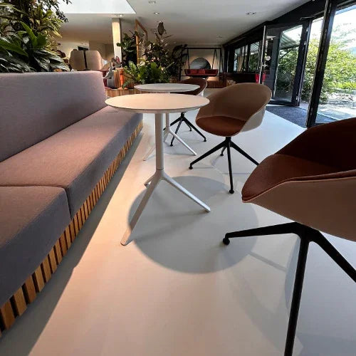 Moderne kantoormeubels met design zitbank, ronde tafel en vergaderstoelen in lichte kantoorruimte