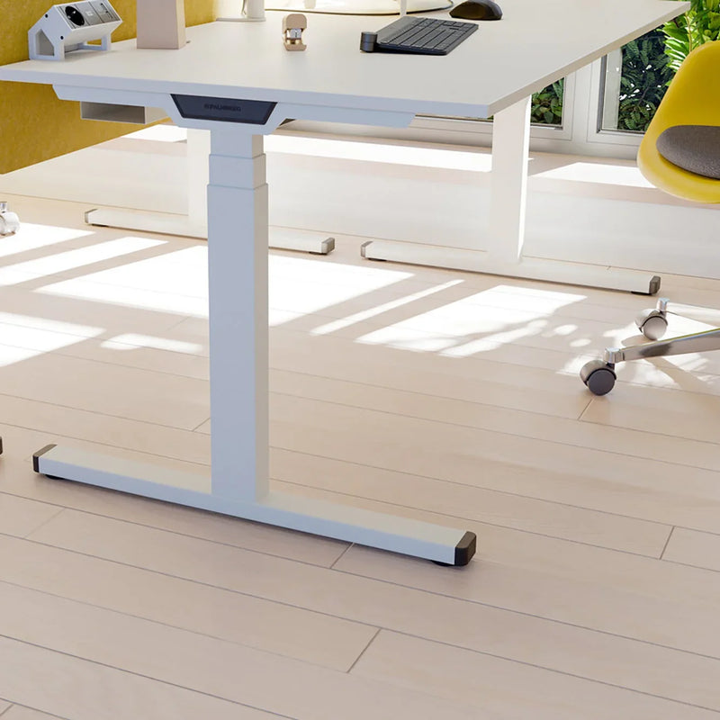 Palmberg zit-sta bureau met wit onderstel in moderne kantoorruimte, ergonomisch kantoormeubilair