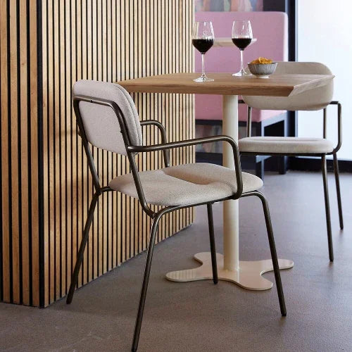 Design vergaderstoel bij ronde tafel met glazen wijn, modern kantoorinterieur sfeer