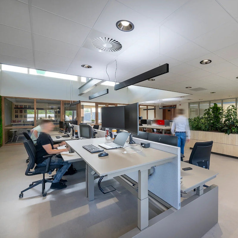 Modern kantoor met design bureaus, ergonomische bureaustoelen en groene plantenwand