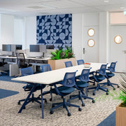 Moderne kantoorinrichting met blauwe ergonomische bureaustoelen, vergadertafel en design akoestisch paneel.
