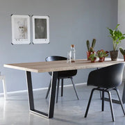 Design vergadertafel met zwarte poot, zwarte stoelen en planten, modern kantoorinterieur