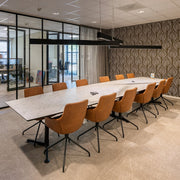 Design vergadertafel met marmerlook blad en leren stoelen in moderne kantoorruimte