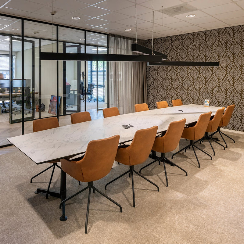 Design vergadertafel met marmerlook blad en leren stoelen in moderne kantoorruimte