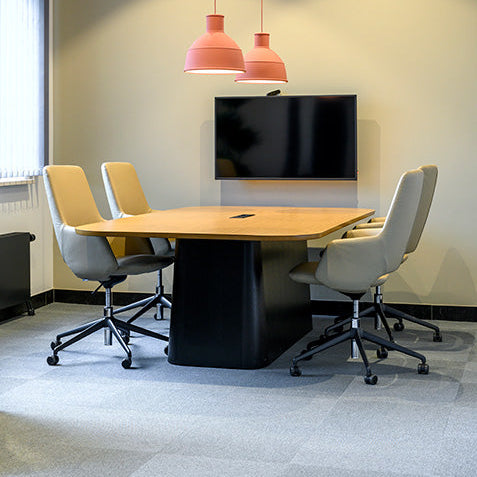 Moderne vergadertafel met comfortabele bureaustoelen, designlampen en flatscreen in kantoor.
