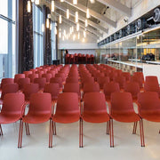 Moderne conferentieruimte met rijen rode zaalstoelen en sfeervolle verlichting, kantoormeubels