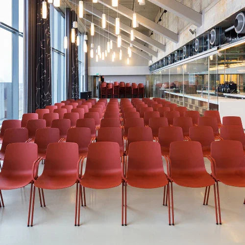 Moderne conferentieruimte met rijen rode zaalstoelen en sfeervolle verlichting, kantoormeubels