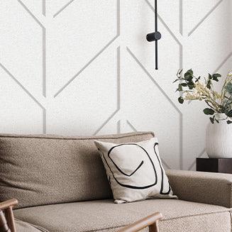 Moderne woonkamer met beige bank, design kussen, decoratieve vaas en minimalistisch wandpaneel (Accent - Tacito)
