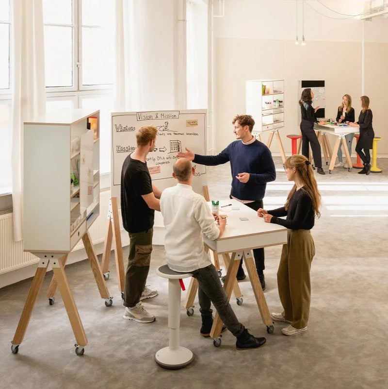 Moderne vergaderruimte met design kantoormeubilair, zit-sta tafels en brainstormende mensen