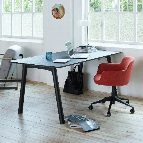 Zwarte design werktafel met rode bureaustoel in moderne kantoorruimte, veel daglicht, kantoormeubilair