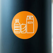 Sticker met pictogram voor plastic, blik en drankkarton afvalscheiding op kantooremming.