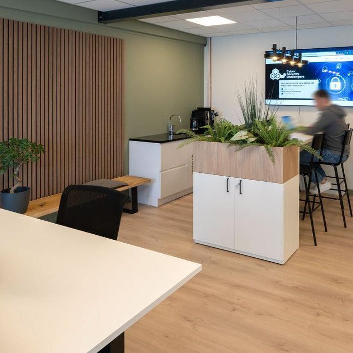 Modern kantoor met PET vilt lattenwand, kantoormeubels, planten en zithoek.