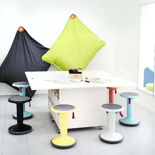 Moderne kantoorruimte met Interstuhl Upis1 balanskrukken rond witte tafel, kleurrijk design