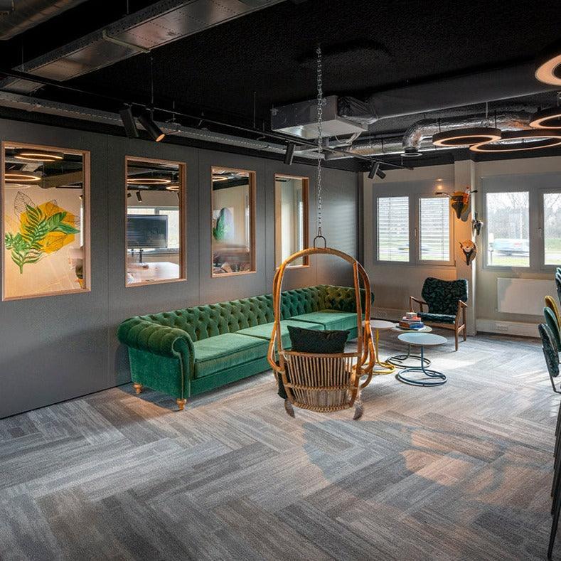 Groene chesterfield bank in modern kantoor met hangstoel en design kantoormeubilair