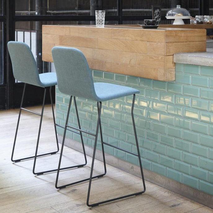 Twee moderne barkrukken bij houten bar, design kantoormeubilair, lichtblauwe bekleding