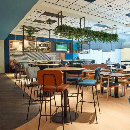 Moderne barkrukken en kantoormeubels in een stijlvolle, open kantoorruimte met planten.