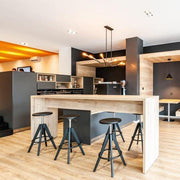 Industriële barkrukken Pedrali Arki met gaslift aan houten tafel in modern kantoorinterieur