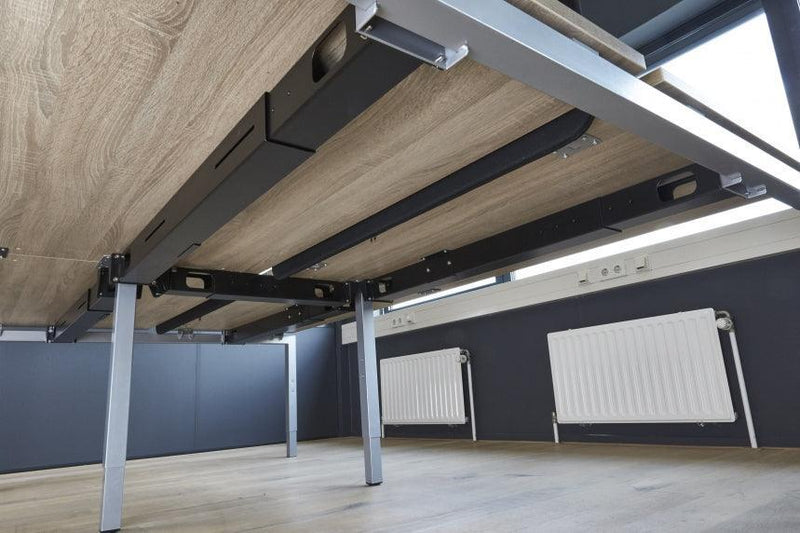 Onderkant van een modern houten kantoortafel met metalen frame in kantoorruimte