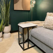 Vierkante bijzettafel met metalen frame en wit blad naast grijze bank in modern kantoorinterieur