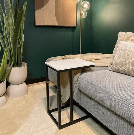 Vierkante bijzettafel met metalen frame en wit blad naast grijze bank in modern kantoorinterieur