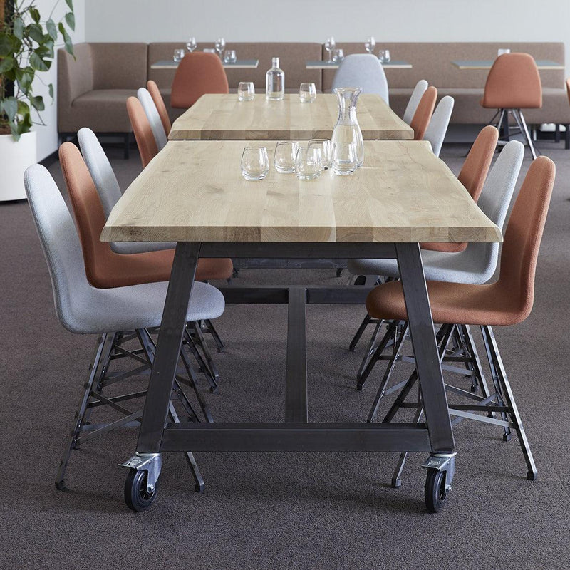 Boomstamtafel met stalen onderstel en design stoelen in moderne kantoorruimte