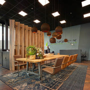 Design vergaderruimte met boomstamtafel, leren stoelen en sfeervolle kantoorverlichting